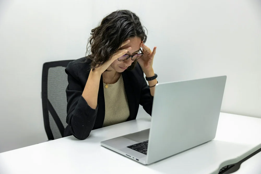 Frau sitzt erschöpft vor einem Laptop